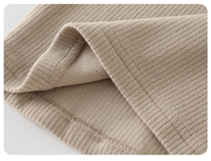 Detailed macro view of the ribbed knit fabric texture and high-quality hem stitching
