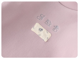 Close-up of winter baby fleece thermal shirt with house and snowman embroidery detail
