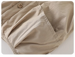 Detail of premium khaki cotton fabric with a wooden button and stitched pocket