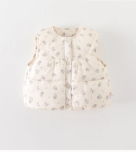 Détail du gilet matelassé pour bébé avec motif floral et fermeture par boutons-pression