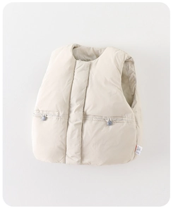 Detail der beige Kinder-Daunenweste mit Steppmuster und seitlichem Pflegeetikett