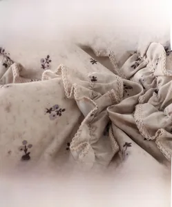 Macro shot of light brown floral fabric with soft ruffles and high-density cotton texture