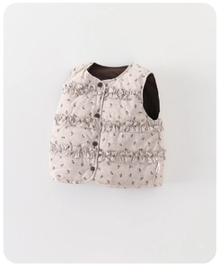 Detail view of quilted floral kids vest with ruffle layers and brown buttons