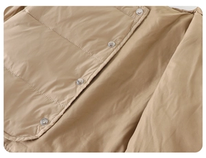 Detail of khaki baby down vest showing premium metallic snaps and quilted fabric texture