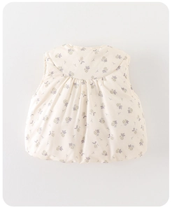 Gros plan détaillé du gilet matelassé pour bébé avec motifs floraux lavande et olive