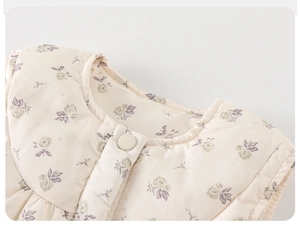 Vue détaillée d'un gilet matelassé à fleurs avec col rond et bouton de couleur claire