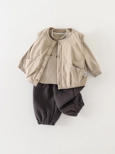 Three-piece warm kids outfit with khaki vest, brown sweater and grey joggers flat lay