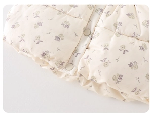 Vue détaillée du gilet matelassé pour enfants avec motifs floraux et boutons-pression