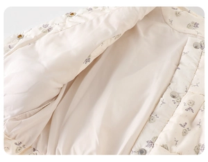 Détail du gilet matelassé à fleurs pour enfants avec boutons-pression métalliques