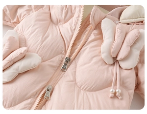 Detail view of pink baby puffer suit with double zippers and decorative bows with pearls