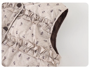 Close-up of girls floral down vest featuring ruffle edges and dark brown buttons