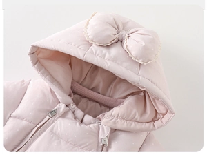 Detail of pink quilted baby winter romper with polka dots, lace trim and 3D bow on hood