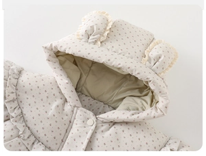 Détail de la veste d'hiver bébé avec motif floral et oreilles d'ours bordées de dentelle