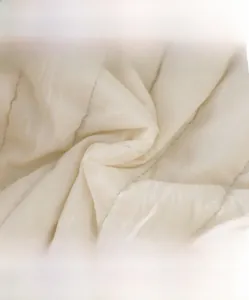 Gros plan sur le tissu matelassé en coton haute densité montrant une texture douce