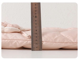 Detailed close-up showing 50mm thickness of pink quilted duck down baby snowsuit fabric