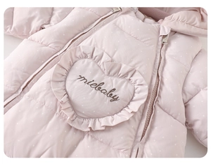 Detail of pink polka dot baby romper showing heart pocket and miebaby embroidery