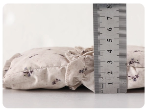 Detail showing the 4.5cm thickness of a floral cotton padded vest with a ruler measurement