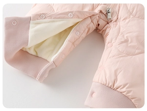 Detail of pink quilted baby romper featuring warm fleece lining and snap closures
