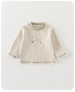 Détail du pull bébé crème avec texte Lucky Baby et broderie d'alpaga mignonne