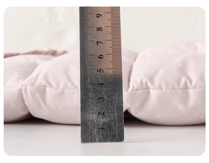 Detail shot showing 6.5cm thickness of pink quilted padded baby romper fabric