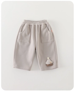 Détail du pantalon gaufré beige pour enfant avec taille élastique et écusson champignon