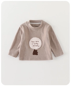 Detail of baby boy cotton long sleeve shirt with bear embroidery and lucky person text