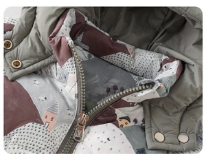 Detail of baby winter jacket showing zip closure, printed lining and quilted windproof fabric