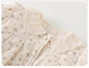 Close-up of quilted floral corduroy cotton jacket with embroidered lace collar