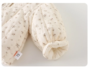 Detailed close-up of quilted floral cotton baby jacket with soft corduroy texture