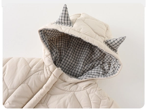 Détail d'une barboteuse hiver bébé avec matelassage en losanges et capuche à oreilles