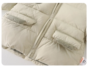 Détail de la veste rembourrée crème pour tout-petit avec poches et fermeture éclair