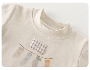 Détail de l'encolure côtelée pour bébé avec patch à carreaux et imprimé chaussette