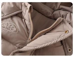 Detail of khaki quilted baby winter coat with metal zipper and oval embroidery patch