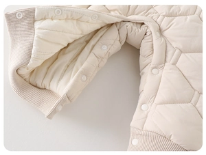 Détail de barboteuse matelassée pour bébé avec poignets côtelés et boutons-pression