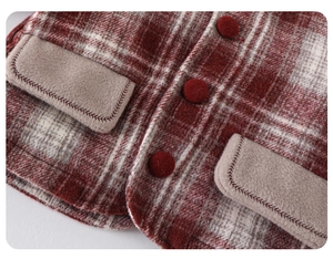 Detail of red plaid wool vest with decorative fabric buttons and fleece pocket flaps
