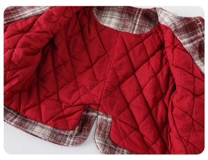 Detail of red quilted lining and plaid wool fabric for warm baby winter coat