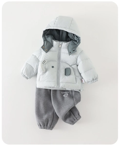 Dettaglio set invernale bimbo con giacca con cappuccio azzurra e pantaloni grigi scuri
