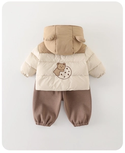 Détail de la tenue d'hiver pour bébé avec veste beige à oreilles d'ours et pantalon marron