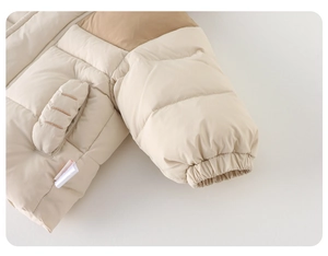 Détail de la veste d'hiver beige pour petit garçon avec poignets élastiques et coutures