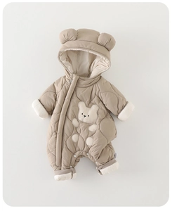 Detail of baby snowsuit featuring quilted brown fabric and a cute bear patch on chest