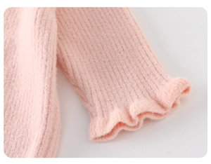 Detailansicht eines rosa Strickpullover-Ärmels mit Rüschenmanschette und Rippenstruktur