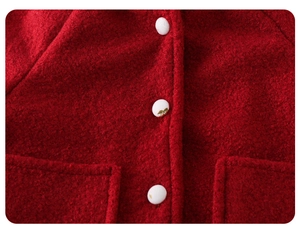 Close-up of red fleece baby coat featuring white buttons with cherry embroidery details