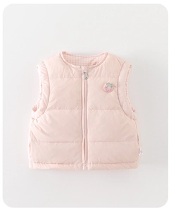 Détail de gilet matelassé rose bébé avec fermeture éclair et écusson de fraise