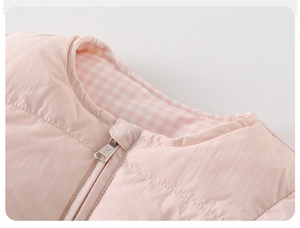 Vue détaillée du gilet matelassé rose pour fille avec col rond et doublure à carreaux