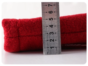 Close-up showing the 6cm thickness of the red felt fabric material with a measuring ruler