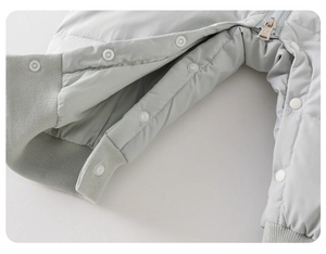 Detail view of baby romper featuring snap buttons, metal zipper and ribbed leg cuffs