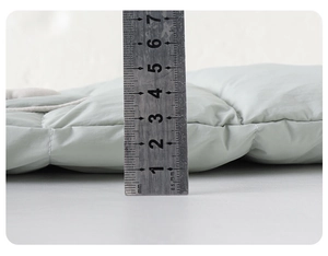 Detailansicht der 4cm Dicke Messung für den grünen gesteppten Daunenoverall
