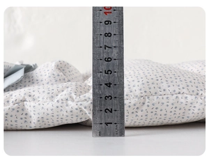 Close-up showing 10cm thickness measurement of a blue floral baby down romper padding