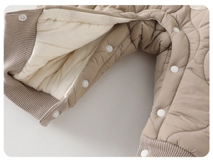 Detailed macro view of quilted baby romper with warm lining and snap button closure