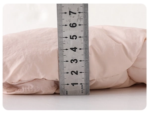 Vue détaillée montrant l'épaisseur de 7 cm et la texture matelassée du gilet rose bébé